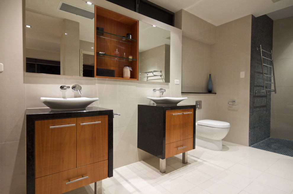 Photo of a large tropical master bathroom in Townsville with a vessel sink, flat-panel cabinets, medium wood cabinets, engineered quartz benchtops, an open shower, white tile, ceramic tile, beige walls and ceramic floors.