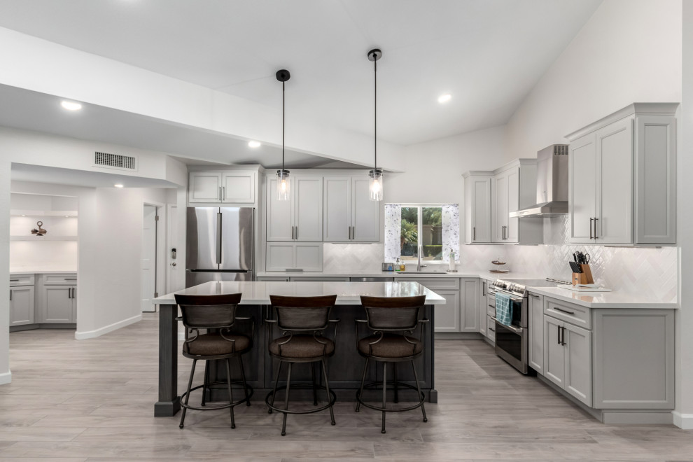 Mid-sized transitional porcelain tile and gray floor eat-in kitchen photo in Phoenix with an undermount sink, shaker cabinets, gray cabinets, quartz countertops, white backsplash, subway tile backsplash, stainless steel appliances, an island and white countertops