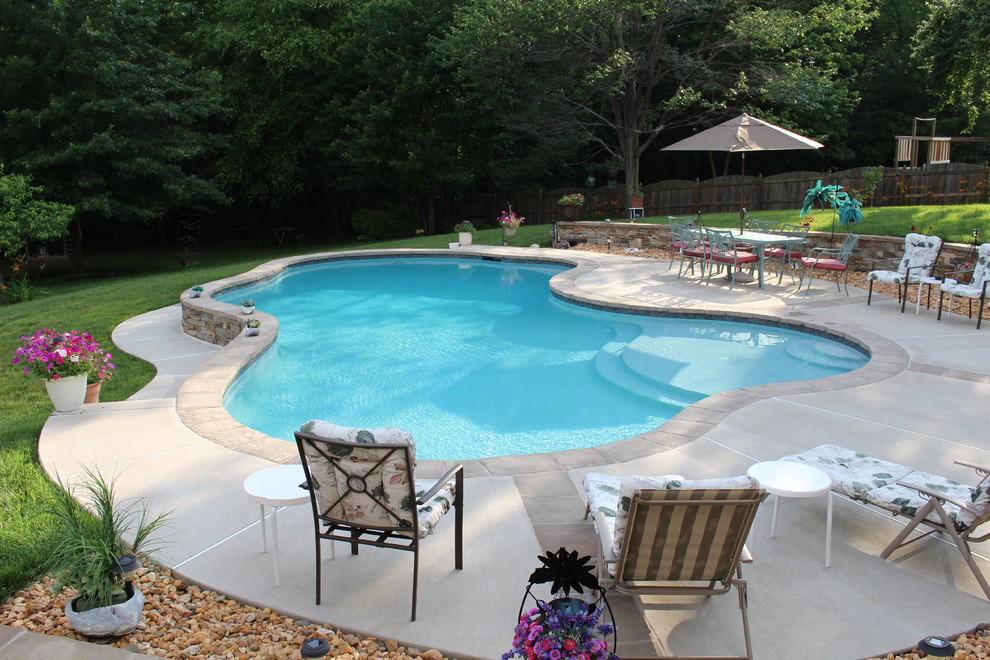 Mid-sized country backyard custom-shaped natural pool in DC Metro with concrete slab.