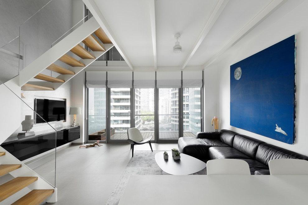 Photo of a modern living room in New York with white walls, no fireplace, a built-in media wall and grey floor.
