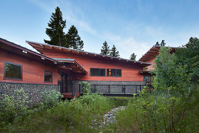 This is an example of an expansive modern three-storey brown exterior in Seattle with wood siding and a flat roof.