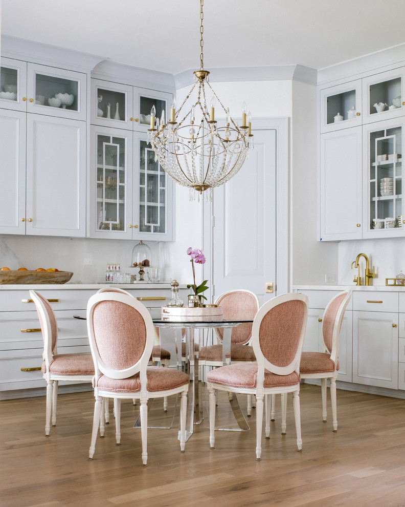This is an example of a traditional dining room in Dallas with white walls and light hardwood floors.