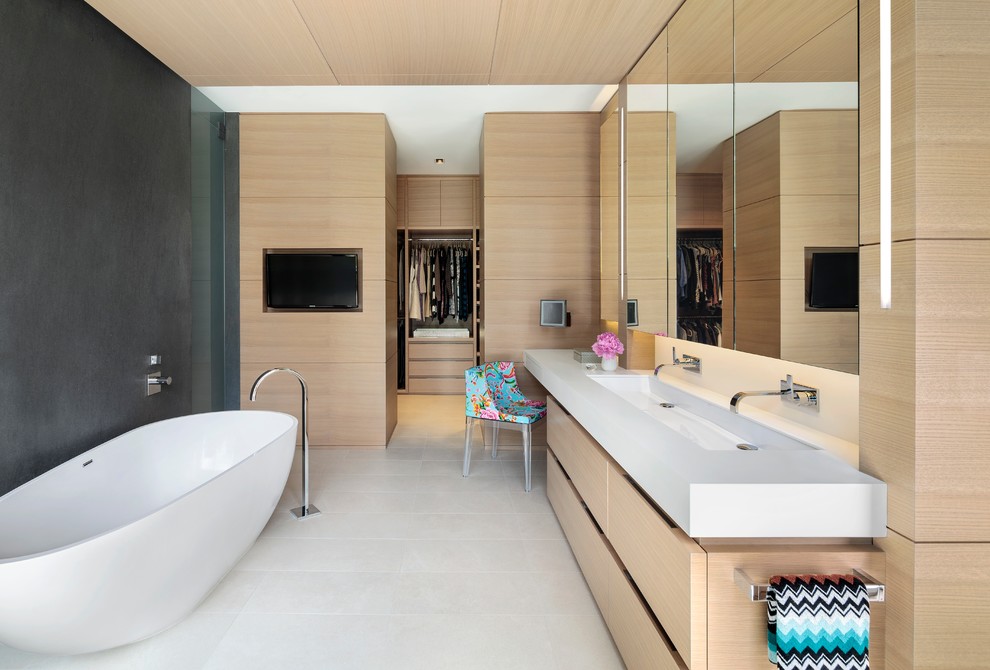 Modern master bathroom in Vancouver with flat-panel cabinets, light wood cabinets, a freestanding tub, grey walls, a trough sink and white floor.