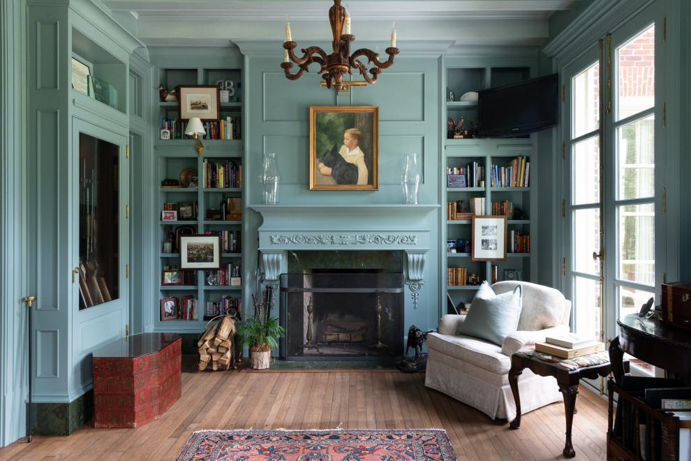 Example of a mid-sized classic enclosed light wood floor, brown floor and wall paneling living room library design in Atlanta with a standard fireplace and a wood fireplace surround