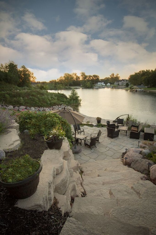 Photo of a mid-sized transitional full sun backyard stone landscaping in Chicago.