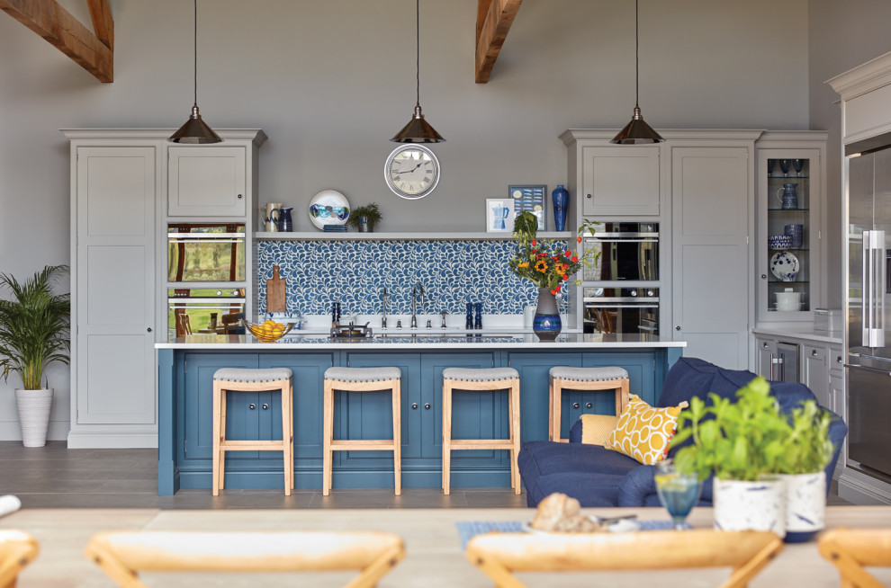 This is an example of a large contemporary l-shaped open plan kitchen in Other with an integrated sink, shaker cabinets, grey cabinets, quartzite benchtops, blue splashback, stone tile splashback, stainless steel appliances, porcelain floors, with island, grey floor and white benchtop.