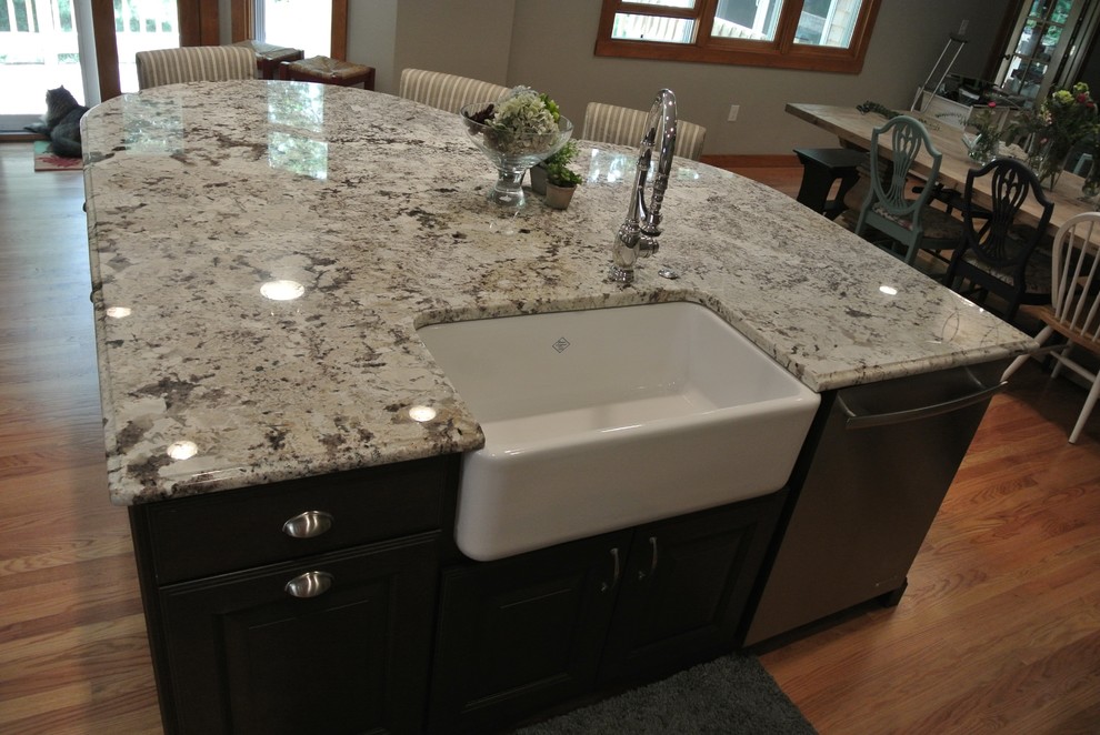 Large transitional l-shaped light wood floor eat-in kitchen photo in Boston with a farmhouse sink, shaker cabinets, gray cabinets, granite countertops, white backsplash, ceramic backsplash, stainless steel appliances, an island and gray countertops