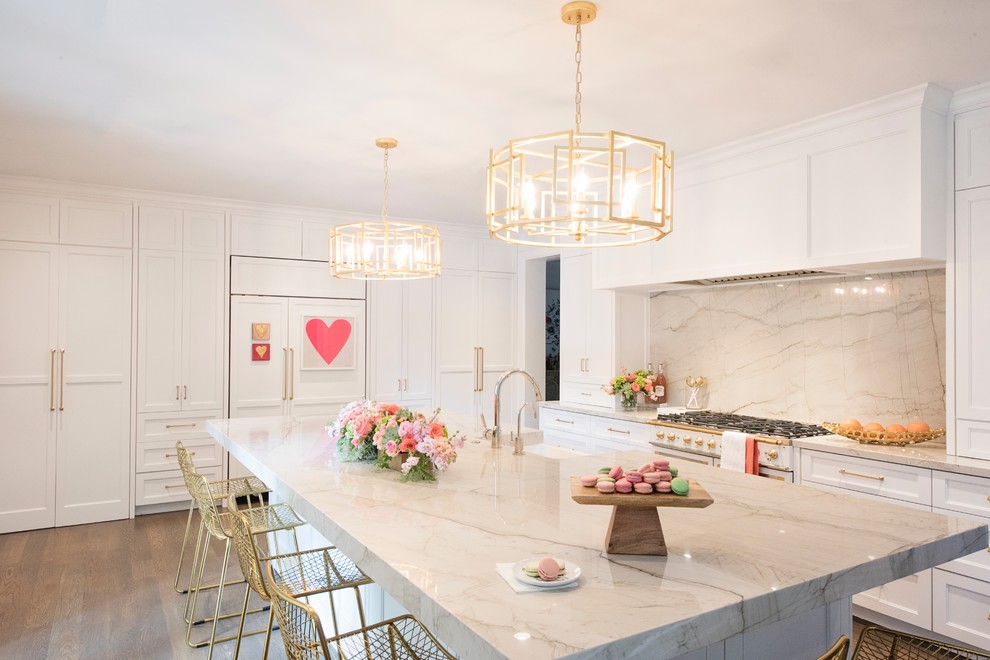 Large transitional l-shaped medium tone wood floor and brown floor open concept kitchen photo with a farmhouse sink, recessed-panel cabinets, white cabinets, quartzite countertops, white backsplash, stone slab backsplash, paneled appliances and an island