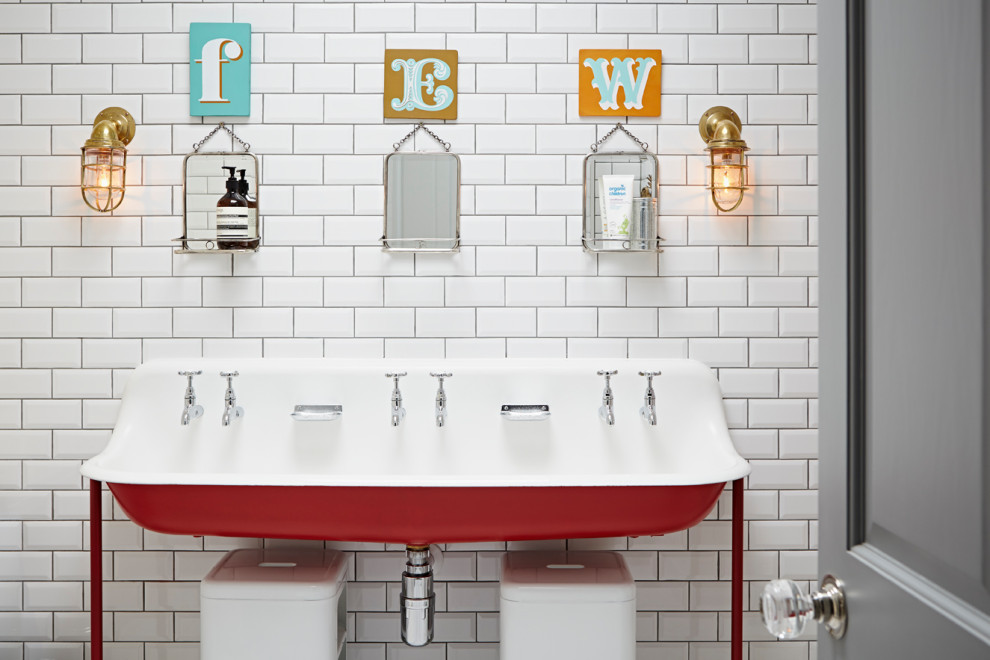 This is an example of an eclectic kids bathroom in London with red cabinets, white tile, subway tile, a freestanding vanity, a trough sink and a single vanity.