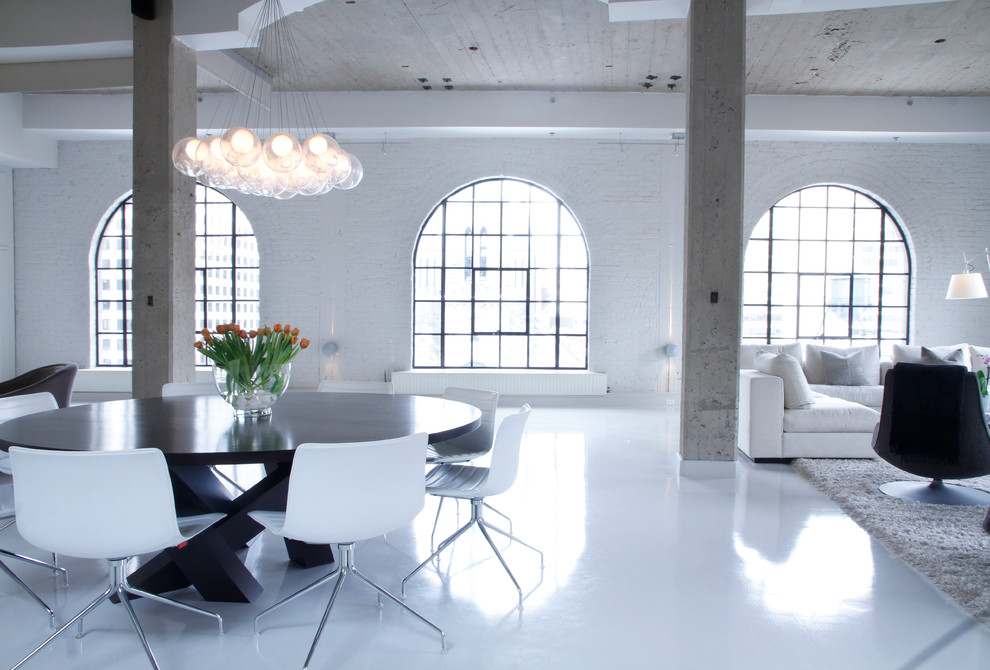 Photo of an expansive industrial living room in Montreal with white walls and white floor.