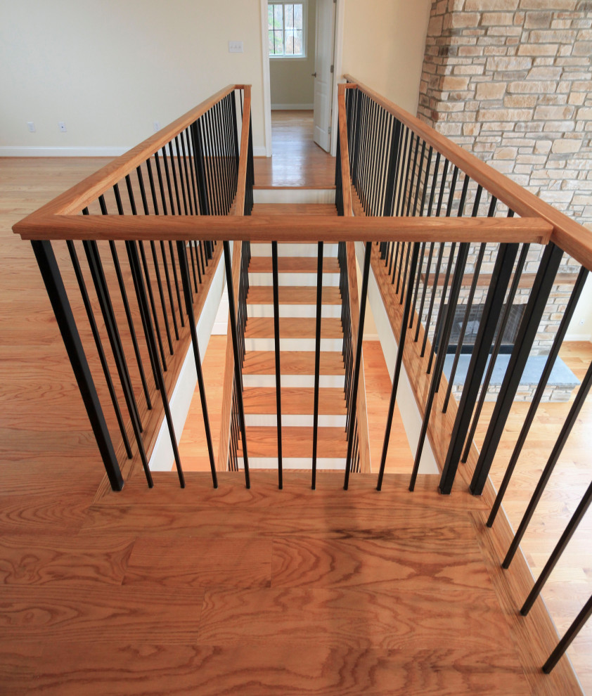 Large classic wood floating mixed railing staircase in DC Metro with wood risers and tongue and groove walls.