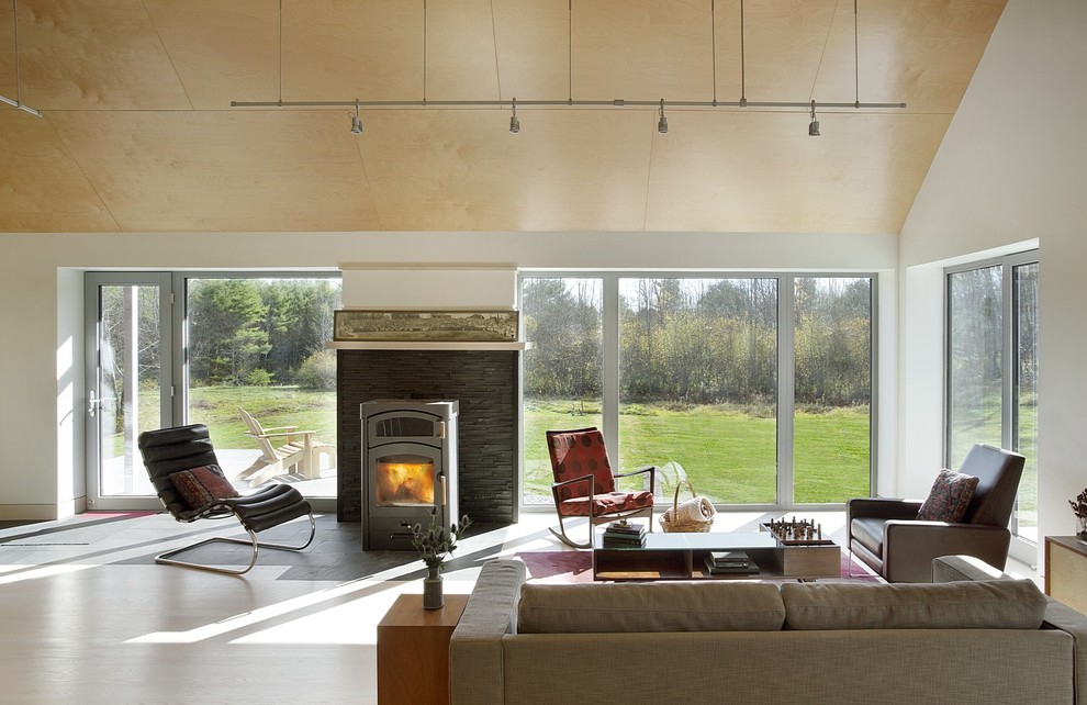 Inspiration for a mid-sized country open concept light wood floor living room remodel in Boston with white walls, a wood stove, a stone fireplace and no tv
