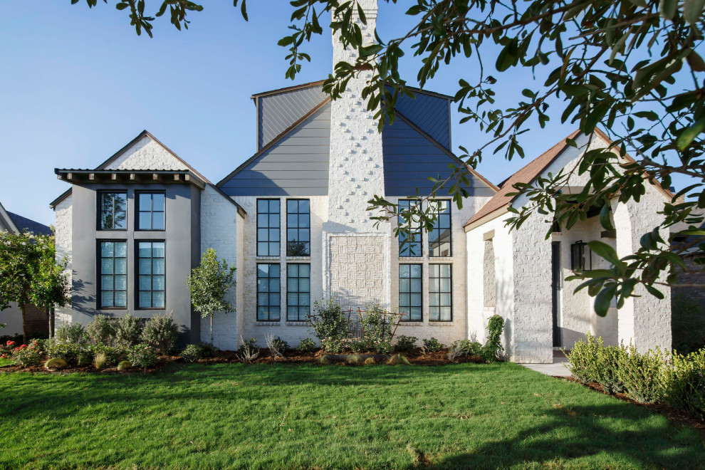 Foto della villa grande bianca contemporanea a un piano con rivestimento in mattoni, tetto a mansarda, copertura a scandole e tetto marrone
