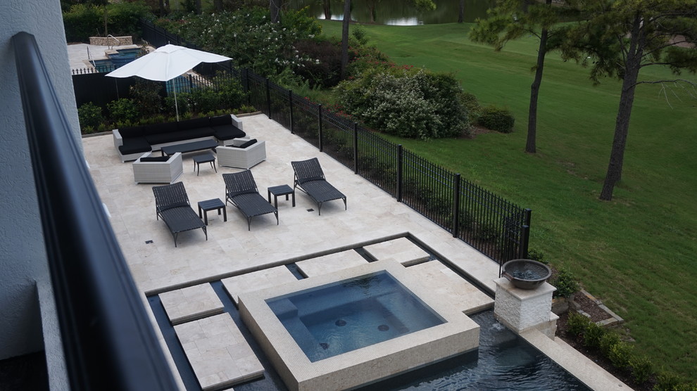 Design ideas for a large contemporary backyard patio in Houston with natural stone pavers and no cover.