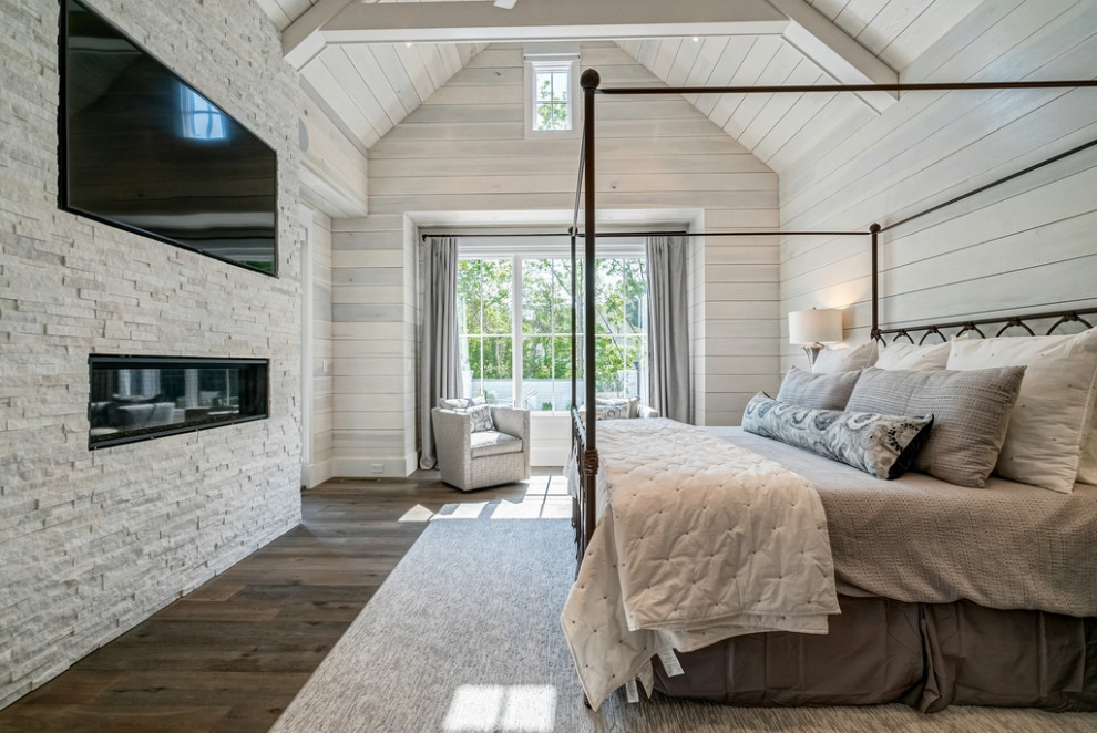 Modernes Hauptschlafzimmer mit weißer Wandfarbe, Kaminumrandung aus Stein, gewölbter Decke und Holzdielenwänden in Atlanta