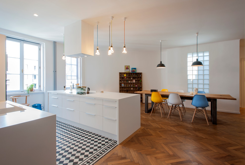 This is an example of a contemporary eat-in kitchen in Other with flat-panel cabinets, white cabinets, medium hardwood floors and with island.