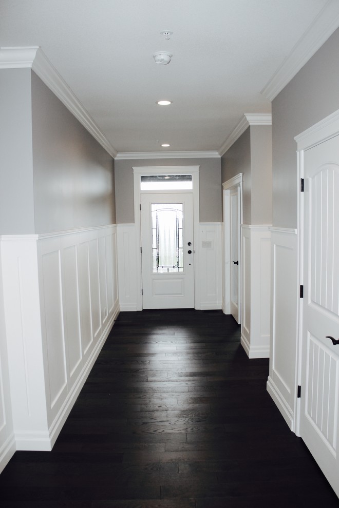 This is an example of an arts and crafts foyer in Vancouver with grey walls, dark hardwood floors, a single front door and a glass front door.