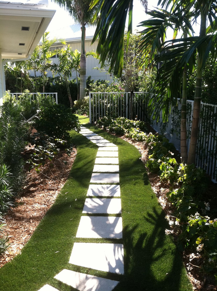 Design ideas for a mid-sized traditional side yard partial sun formal garden in Miami with natural stone pavers.