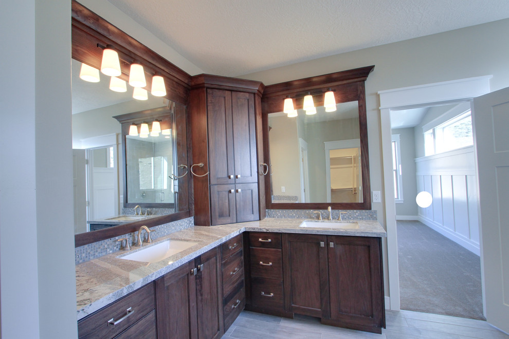Photo of a large arts and crafts master bathroom in Salt Lake City with shaker cabinets, dark wood cabinets, gray tile, glass tile, beige walls, ceramic floors, an undermount sink and beige floor.