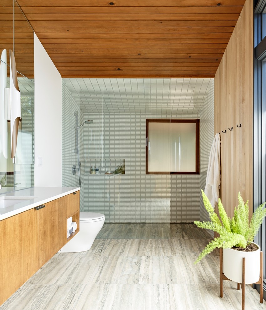 Inspiration for a midcentury bathroom in Portland with flat-panel cabinets, medium wood cabinets, a curbless shower, white tile, mosaic tile, red walls, an undermount sink, grey floor, an open shower and white benchtops.