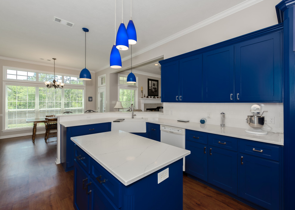 Inspiration for a transitional vinyl floor and brown floor eat-in kitchen remodel in Austin with shaker cabinets, blue cabinets, quartz countertops, white backsplash, ceramic backsplash, an island and white countertops