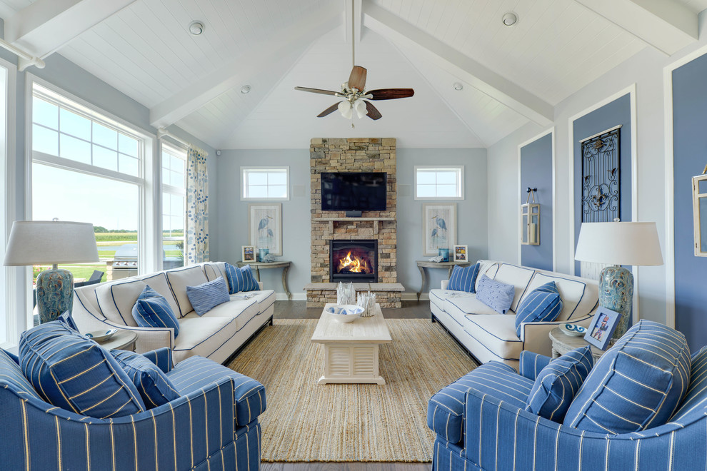Design ideas for a beach style formal open concept living room in Other with blue walls, a freestanding tv, a standard fireplace and a brick fireplace surround.