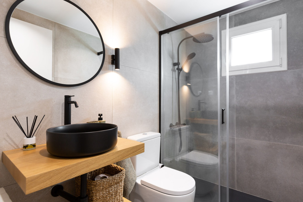 Inspiration for a small contemporary 3/4 gray tile porcelain tile, gray floor and single-sink bathroom remodel in Barcelona with black cabinets, a one-piece toilet, gray walls, a vessel sink, wood countertops and brown countertops