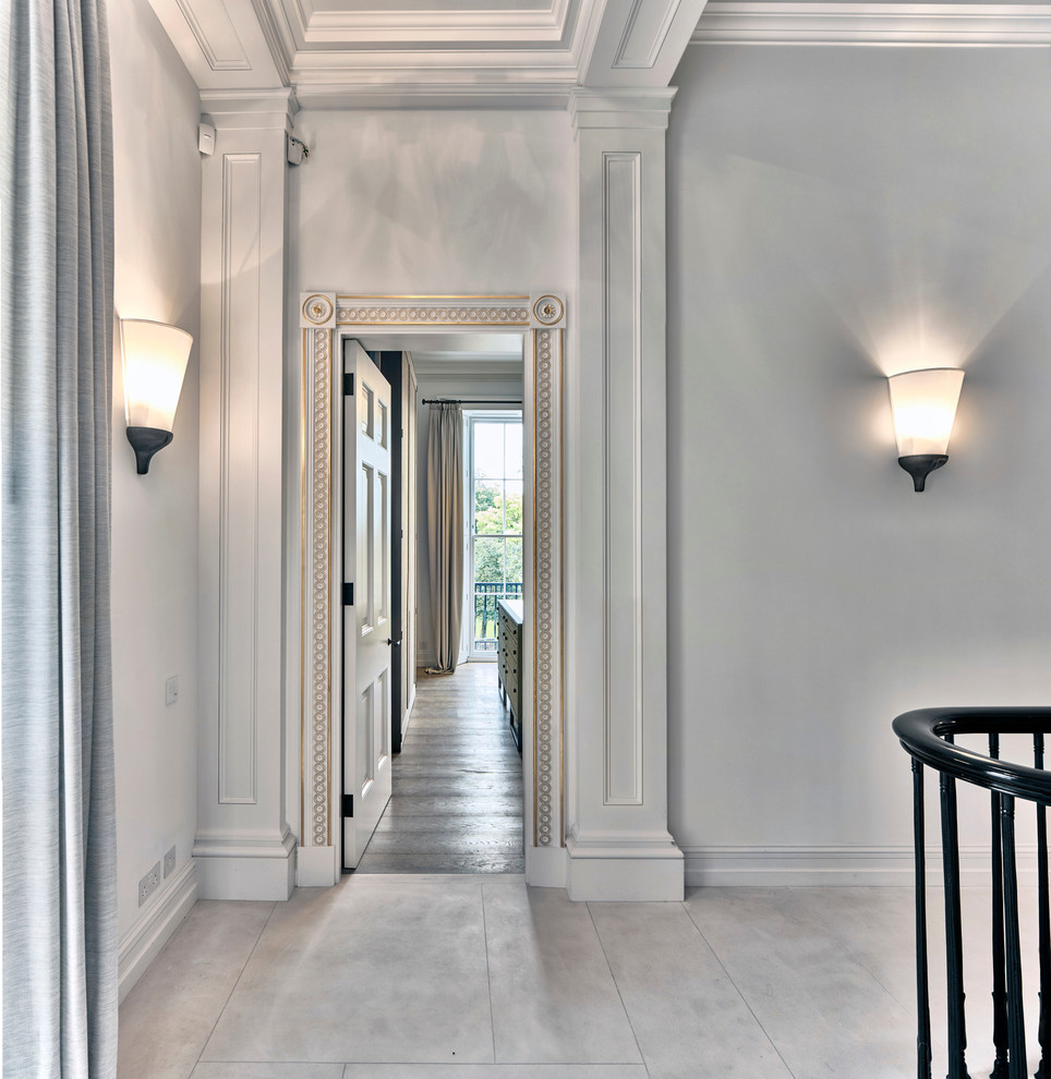 Expansive hallway in London with white walls and travertine floors.