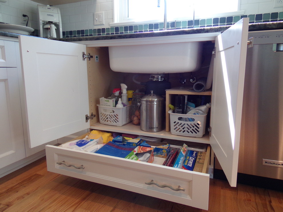 Inspiration for a mid-sized transitional l-shaped light wood floor enclosed kitchen remodel with an undermount sink, flat-panel cabinets, white cabinets, granite countertops, white backsplash, subway tile backsplash, stainless steel appliances and no island