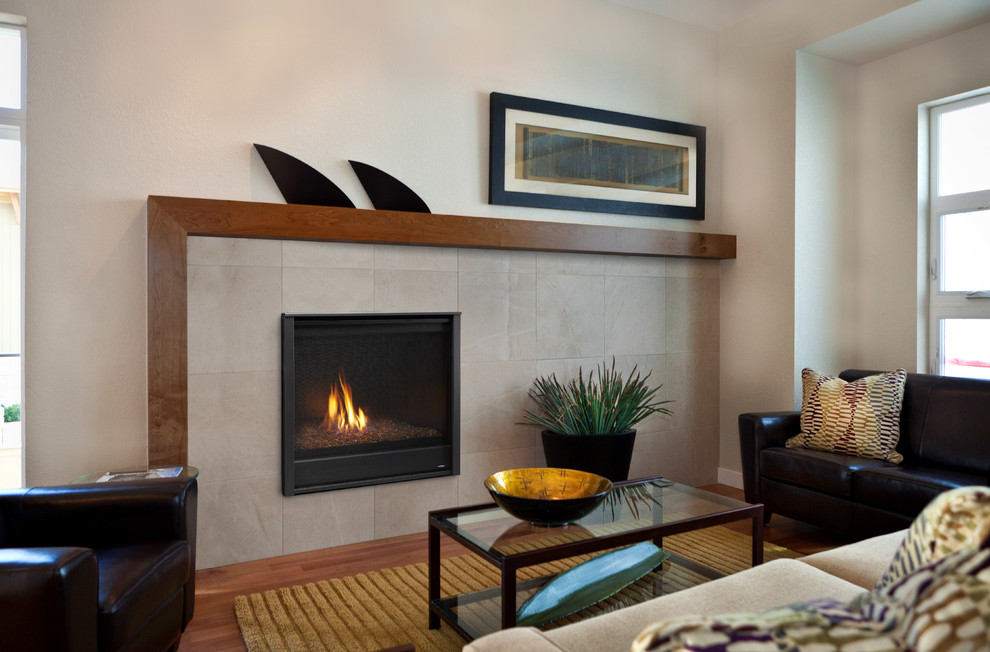 This is an example of a mid-sized modern formal open concept living room in Boston with beige walls, light hardwood floors, a standard fireplace, a tile fireplace surround, no tv and beige floor.