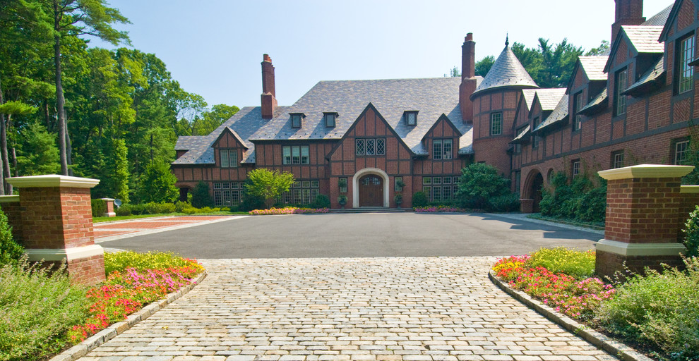 Photo of an expansive traditional three-storey brick red house exterior in New York with a hip roof and a shingle roof.