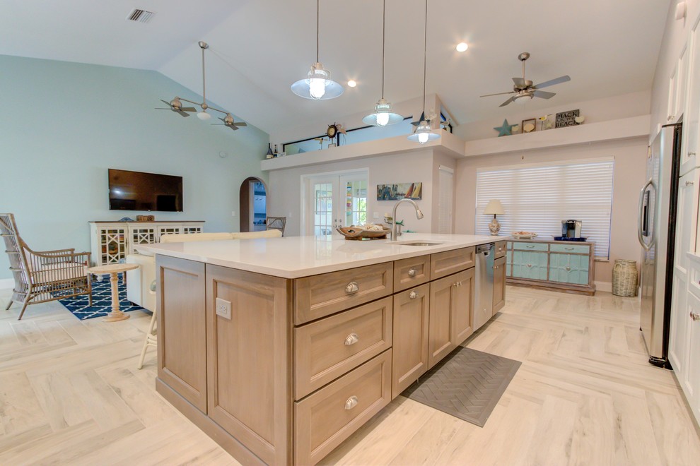Large single-wall porcelain tile and white floor open concept kitchen photo with an undermount sink, shaker cabinets, white cabinets, quartz countertops, blue backsplash, stainless steel appliances, an island and white countertops