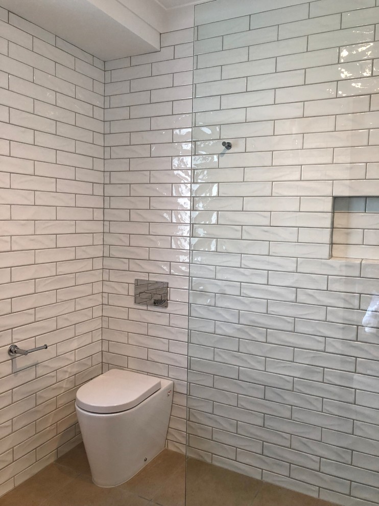 This is an example of a mid-sized contemporary master bathroom in Other with furniture-like cabinets, light wood cabinets, an open shower, a one-piece toilet, white tile, ceramic tile, white walls, ceramic floors, a vessel sink, granite benchtops, beige floor, an open shower and multi-coloured benchtops.
