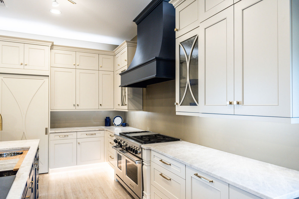 Example of a mid-sized classic l-shaped vinyl floor and beige floor kitchen pantry design in Other with a single-bowl sink, recessed-panel cabinets, white cabinets, quartzite countertops, white backsplash, ceramic backsplash, stainless steel appliances, an island and white countertops