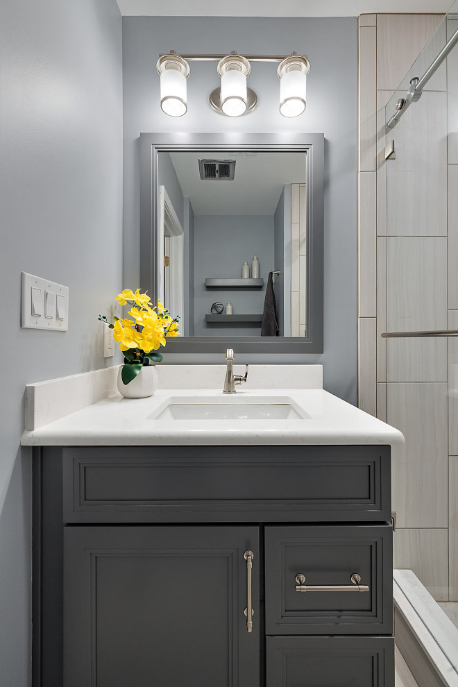 Пример оригинального дизайна: ванная комната среднего размера в морском стиле с фасадами в стиле шейкер, серыми фасадами, душем в нише, раздельным унитазом, серой плиткой, керамической плиткой, синими стенами, полом из керамической плитки, душевой кабиной, врезной раковиной, столешницей из искусственного кварца, серым полом, душем с раздвижными дверями, белой столешницей, нишей, тумбой под одну раковину и встроенной тумбой