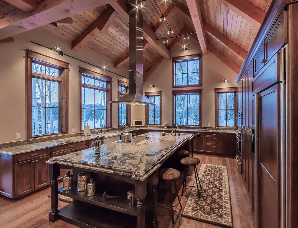 Inspiration for an expansive country u-shaped kitchen in Denver with a farmhouse sink, recessed-panel cabinets, dark wood cabinets, panelled appliances, dark hardwood floors and with island.