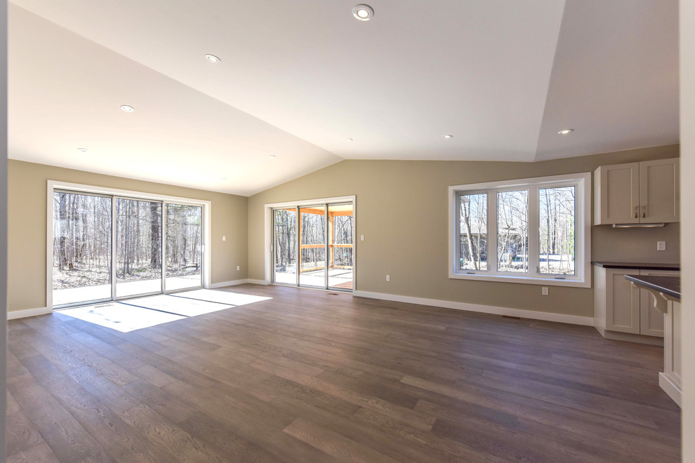 Mid-sized contemporary open concept family room in Toronto with beige walls, medium hardwood floors and brown floor.