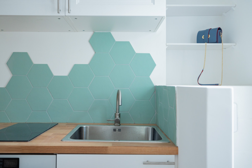 モンペリエにある低価格の小さな北欧スタイルのおしゃれなキッチン (アンダーカウンターシンク、木材カウンター、緑のキッチンパネル、セラミックタイルのキッチンパネル、白い調理設備、セメントタイルの床、青い床、茶色いキッチンカウンター) の写真