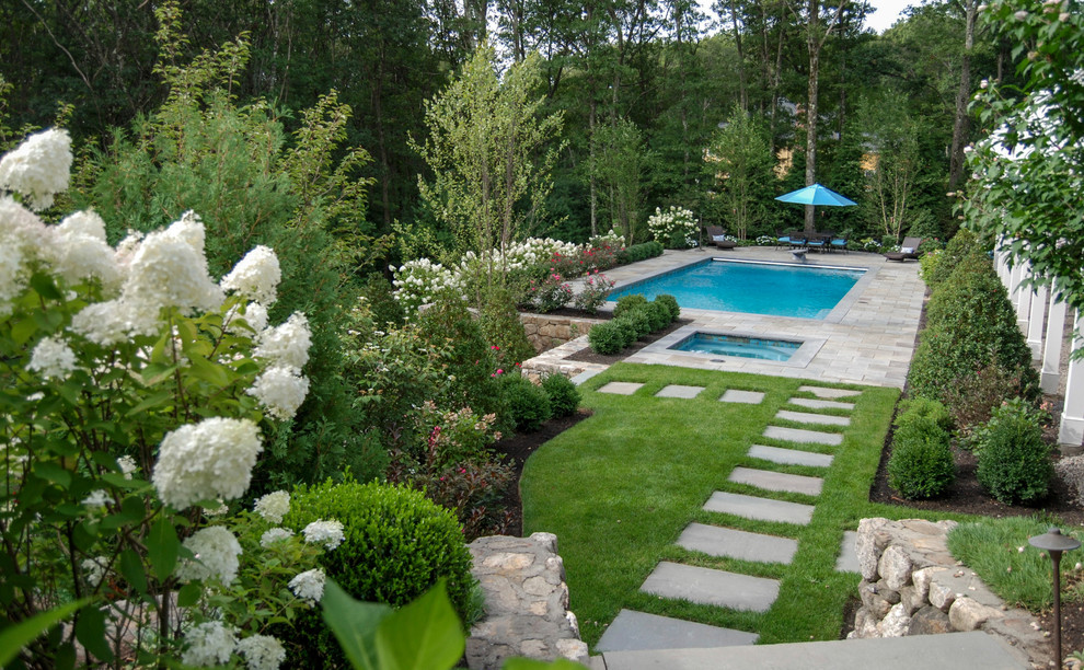 Design ideas for a mid-sized traditional full sun backyard stone retaining wall landscape in Boston.