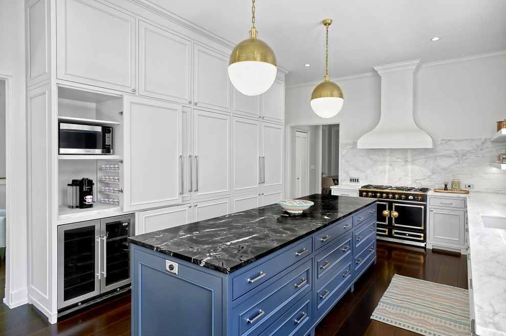 Inspiration for a large transitional galley kitchen in Chicago with an undermount sink, recessed-panel cabinets, white cabinets, marble benchtops, white splashback, marble splashback, black appliances, dark hardwood floors, with island, brown floor and white benchtop.