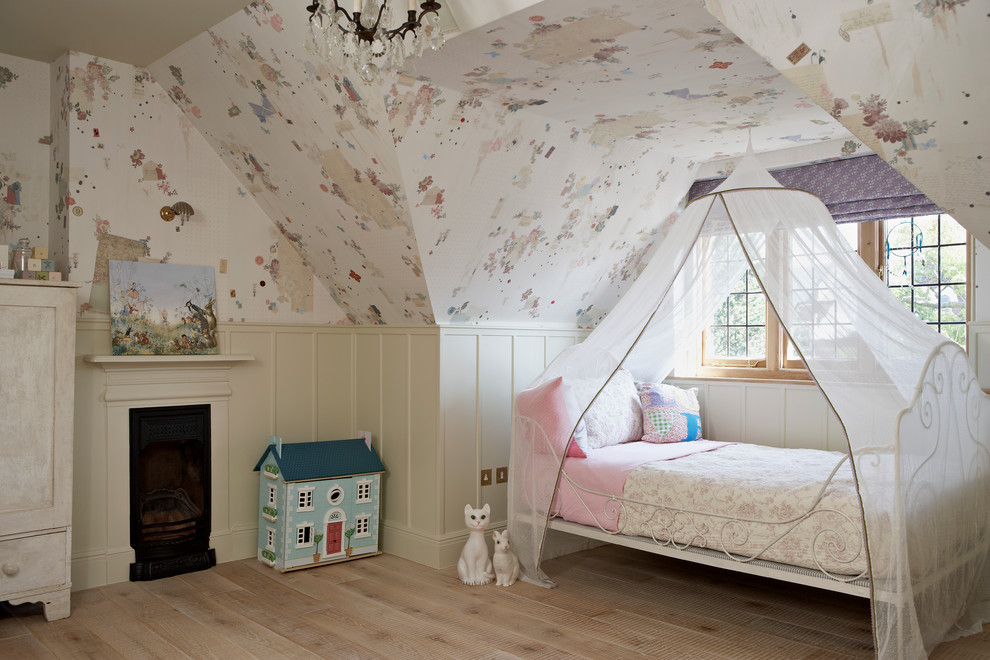 Inspiration for a traditional kids' bedroom for girls in London with multi-coloured walls and light hardwood floors.
