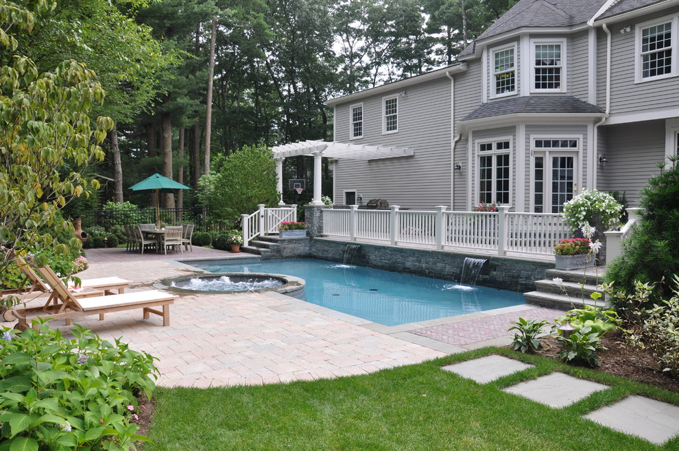 Design ideas for a mid-sized traditional backyard rectangular lap pool in Boston with a hot tub and brick pavers.