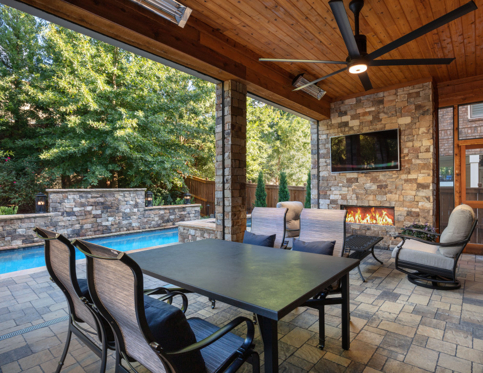 Example of a small trendy backyard stone patio design in Atlanta with a fireplace and a roof extension