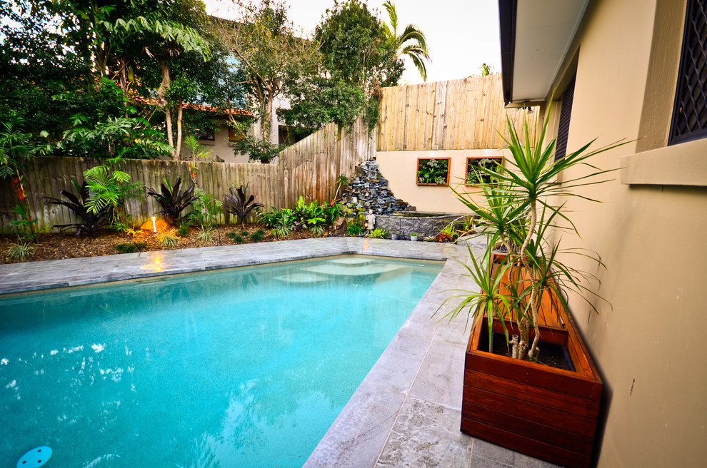 This is an example of a mid-sized asian backyard custom-shaped lap pool in Other with concrete pavers.