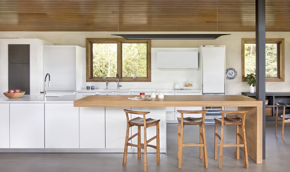 Immagine di una cucina bohémian di medie dimensioni con lavello sottopiano, ante lisce, ante bianche, elettrodomestici in acciaio inossidabile e pavimento in marmo