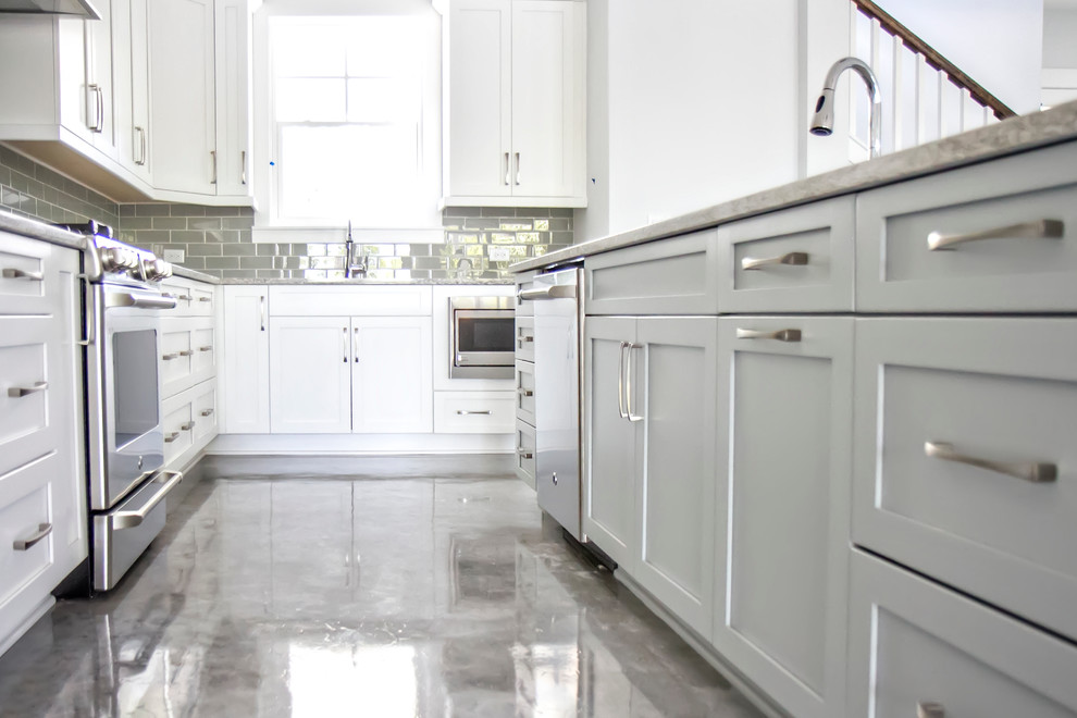 Design ideas for a mid-sized modern l-shaped eat-in kitchen in Jacksonville with an undermount sink, shaker cabinets, white cabinets, granite benchtops, grey splashback, subway tile splashback, stainless steel appliances, concrete floors and with island.