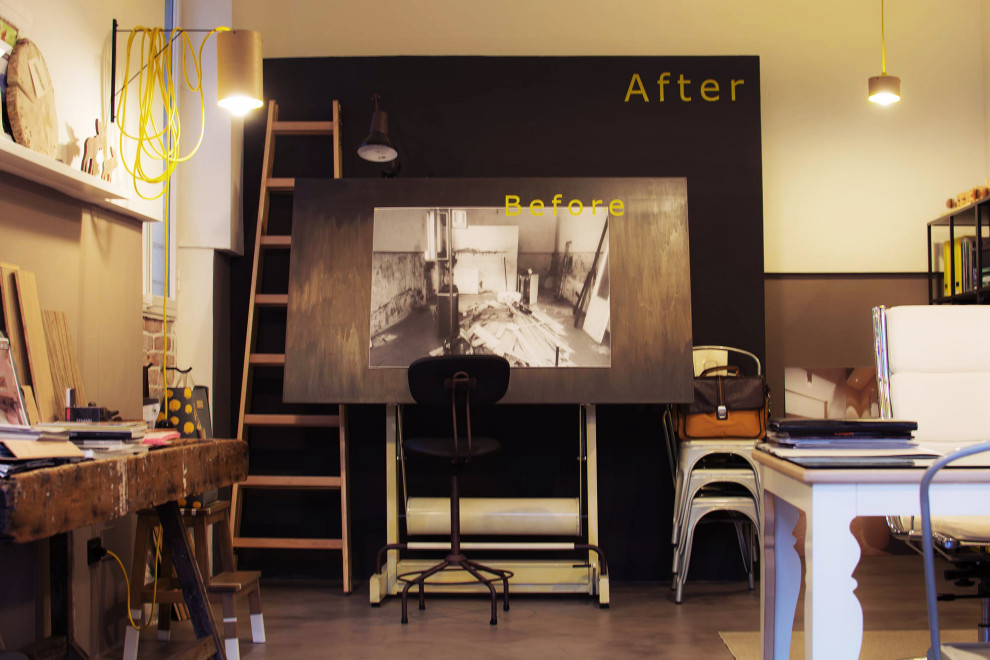 Mittelgroßes Arbeitszimmer mit Studio, brauner Wandfarbe, Betonboden, freistehendem Schreibtisch, grauem Boden und gewölbter Decke in Florenz