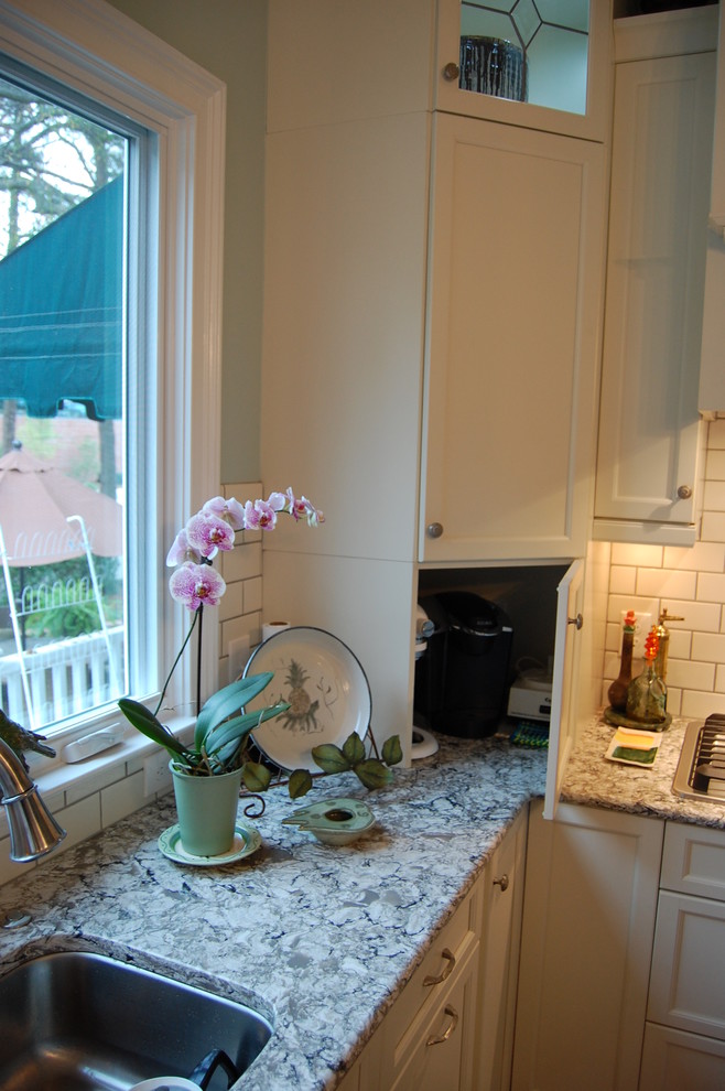 Example of a transitional u-shaped eat-in kitchen design in Raleigh with an undermount sink, recessed-panel cabinets, white cabinets, quartzite countertops, white backsplash, subway tile backsplash and stainless steel appliances