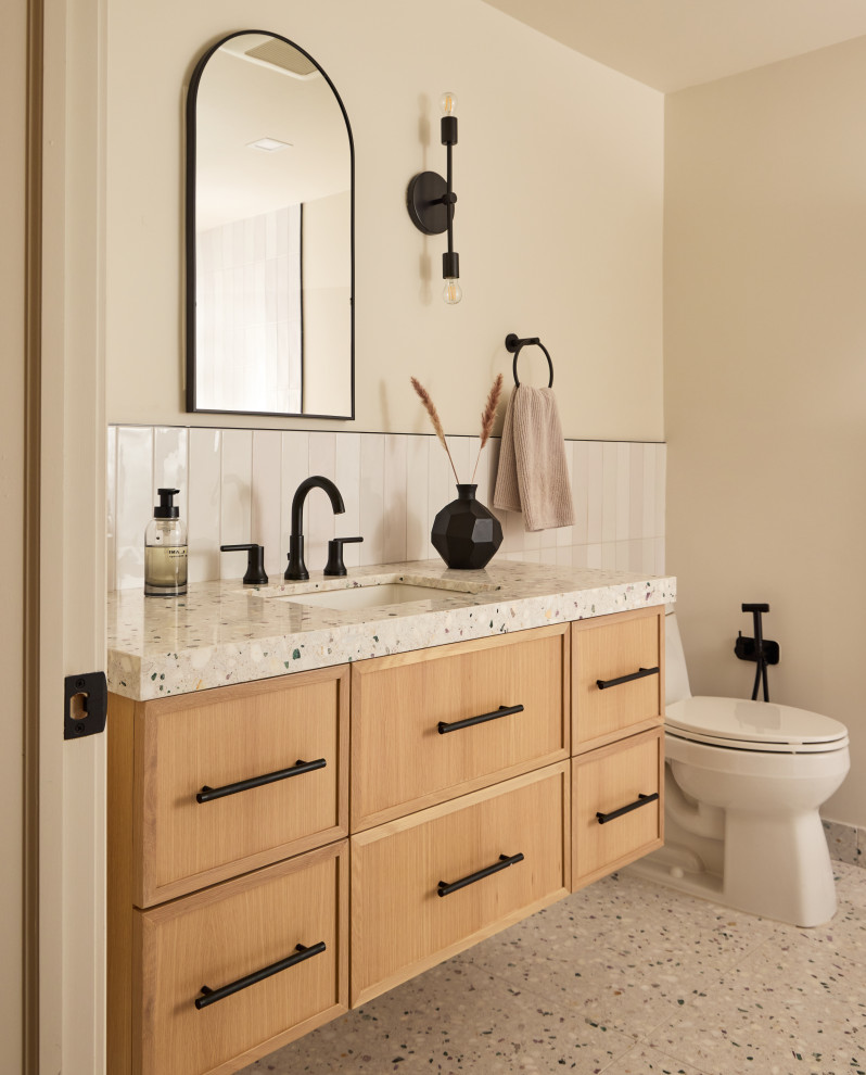 Mid-sized scandinavian 3/4 bathroom in New York with beaded inset cabinets, light wood cabinets, a curbless shower, a one-piece toilet, terrazzo floors, an undermount sink, quartzite benchtops, a sliding shower screen, a single vanity and a floating vanity.
