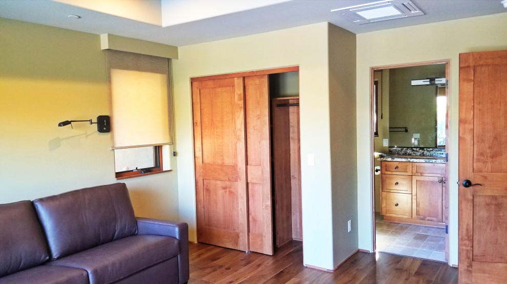 Diseño de habitación de invitados contemporánea de tamaño medio con paredes verdes, suelo de madera en tonos medios, suelo marrón y casetón